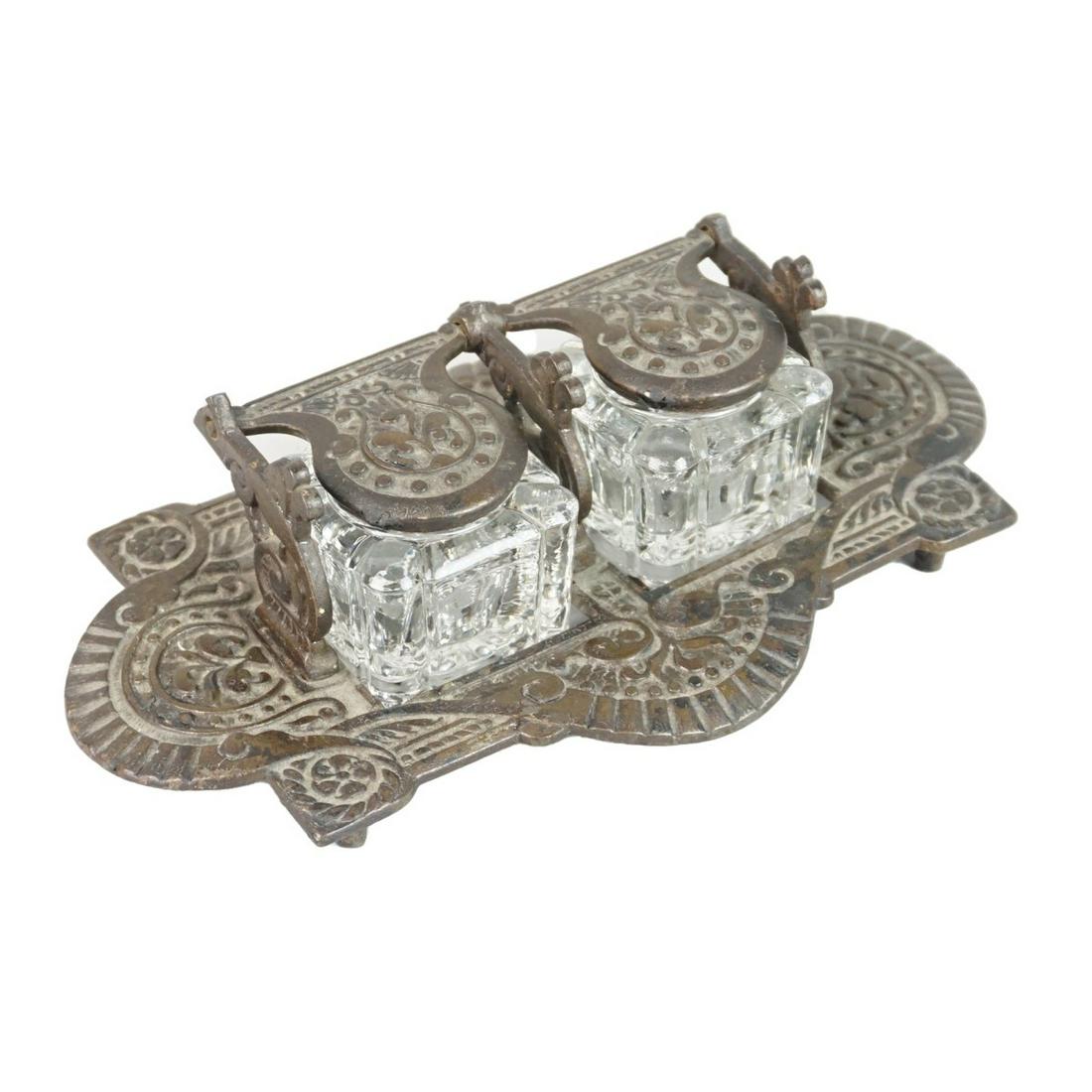 Inkwell: Vintage Victorian Cast Iron Double Inkwell. Glass bottles to accompany the lot. "F" mark stamped on the bottom side. Measures 2-1/2" x 8-1/2" x 5-1/4". Condition: Good condition. Estimate: $50.00 - $1