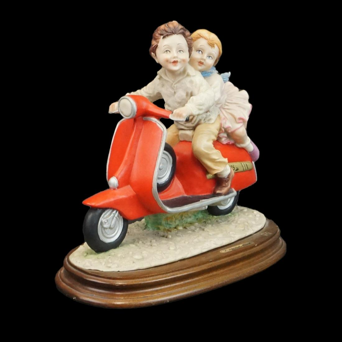 Italian Figurine: Vintage Capodimonte Italian L'Arte Nel Mondo Figurine Presented on Wooden Base. Overall measures 11" x 12-1/2" x 6-3/4". Condition: Good condition. Estimate: $50.00 - $150.00 Domestic Shipping: Third 
