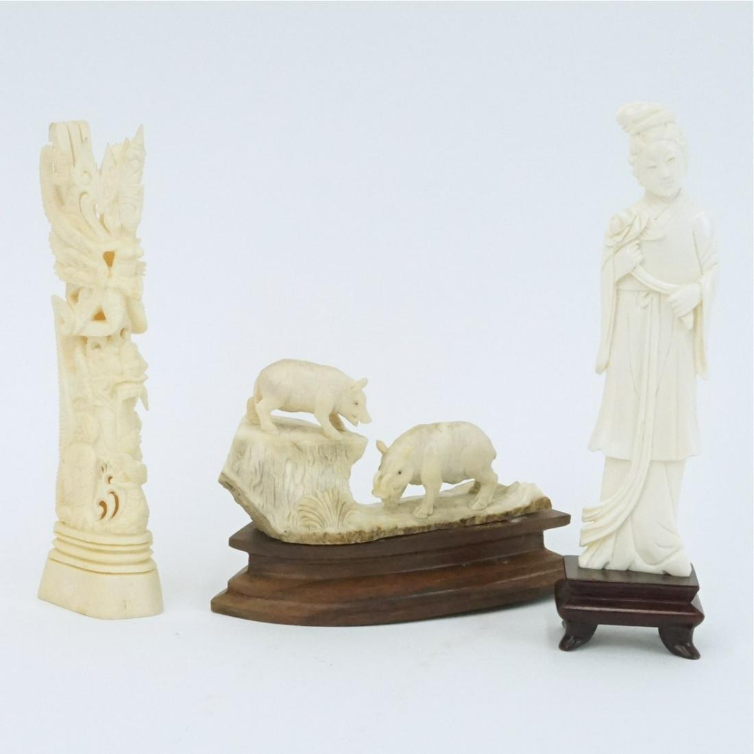 Assorted Figurines: Lot of Three Assorted Carved Figurines. Includes a Chinese Guanyin figure presented on a wooden base, Balinese figural carved bone totem, and a Continental carved bone wild boar group presented on woo