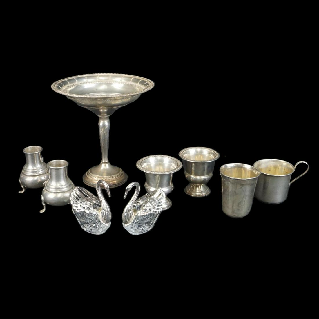 Tableware: Collection of Nine Assorted Sterling Silver Tableware. Lot consists of a weighted compote, a pair of crystal and sterling swan salts, pair of shakers, two weighted egg cups, and two cups. Swans aren't