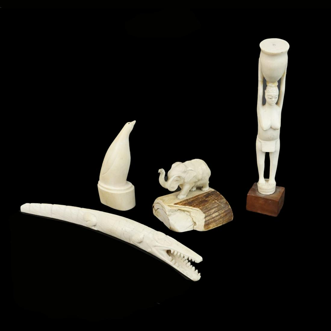 Assorted Figurines: Grouping of Four Assorted Carved Figurines to Include a African Carved Crocodile, African Carved Elephant, Bone Carved Inuit Figurine, and a African Carved Nude Figurine with Basket. Crocodile measure
