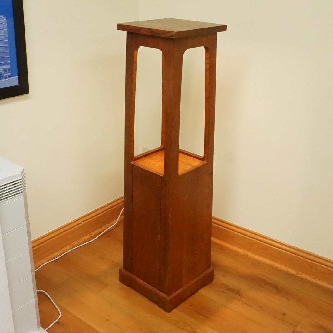Stickley Pedestal: L & J.G. Stickley Arts & Craft Oak Electrified Pedestal. Features a single door with interior shelves. Measures 46-1/8" x 12-1/4" on the base. Condition: Very good condition. Estimate: $200.00 - $500.