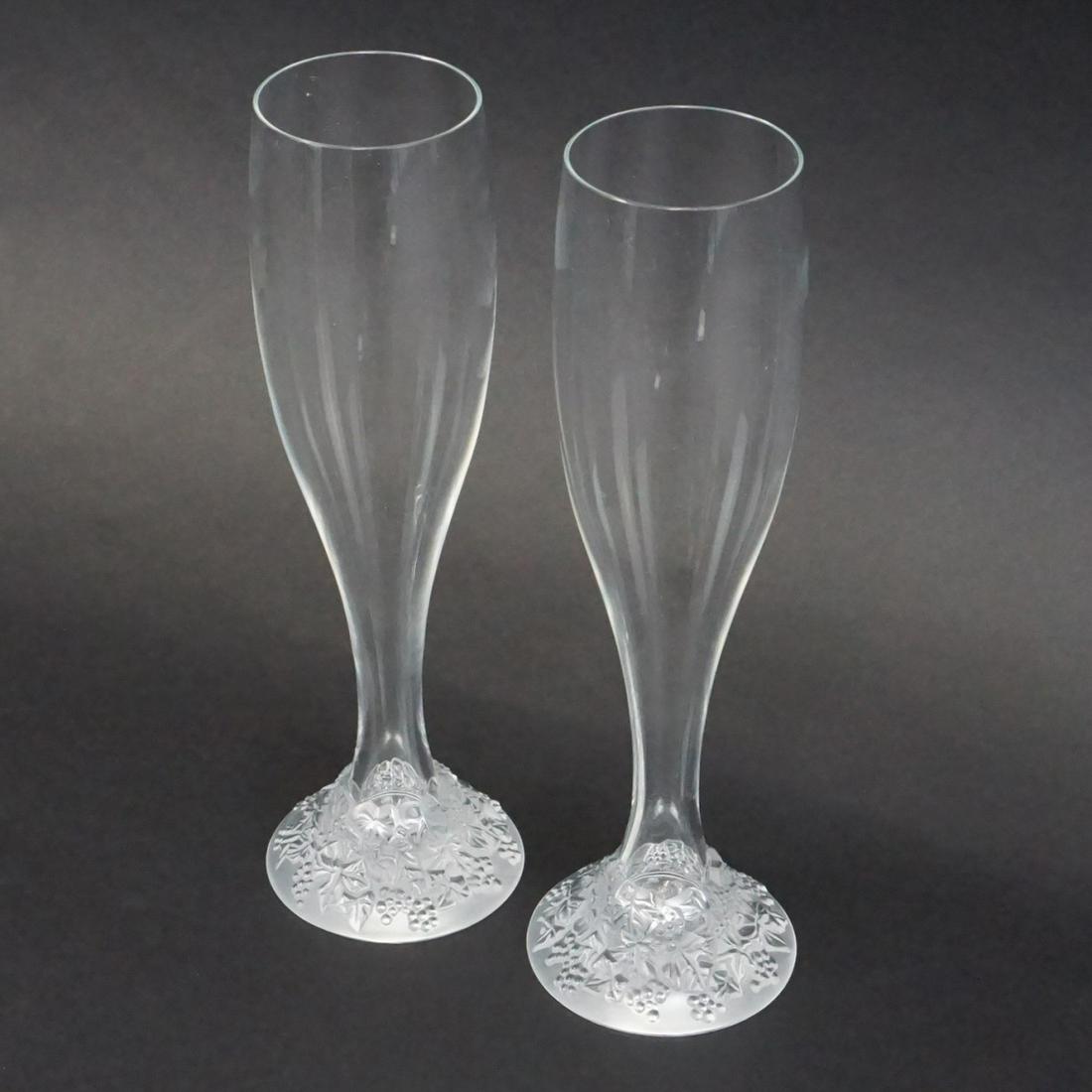 Pair of Lalique Toasting Flutes: Pair of Lalique Celebration 2000 Crystal Toasting Flutes. Signed. Measures 9-3/8" x 2-1/8" diameter top. Condition: Good condition. Estimate: $200.00 - $400.00 Domestic Shipping: $62.00