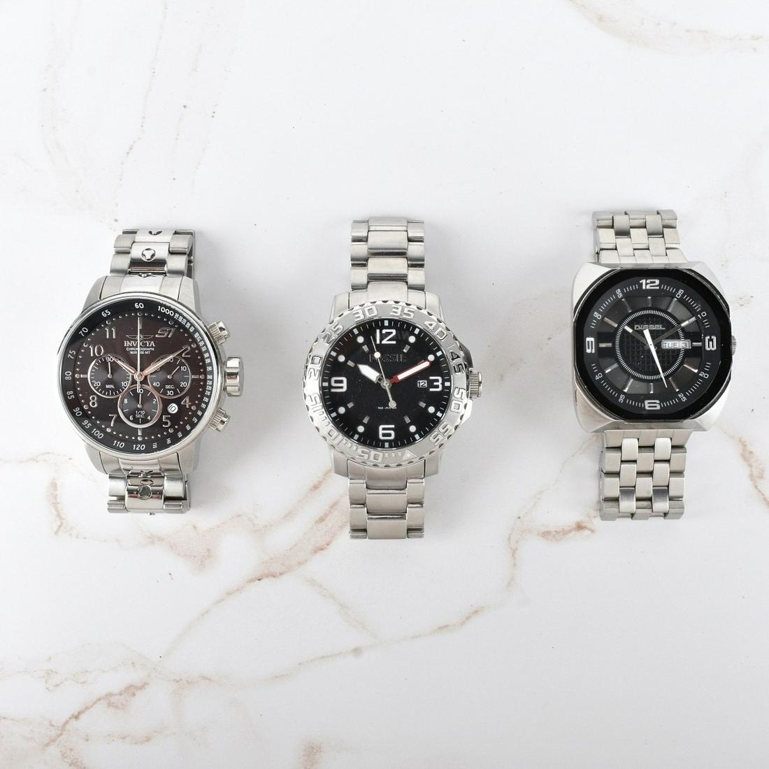 Men's Stainless Steel Watches: Lot of Three Men's Stainless Steel Watches. Lot includes a Fossil 10 ATM with black dial, Invicta Chronograph with black dial, and a Diesel with black dial. Invicta measures 48mm. Fossil measures 48mm