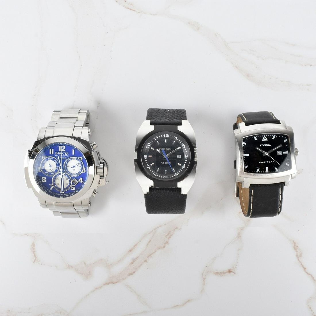 Men's Vintage Stainless Steel Watches: Lot of Three Men's Vintage Stainless Steel Watches. Lot includes a Fossil Arkitekt with black dial and leather bracelet, Invicta Reserve Chronograph with blue dial and stainless steel bracelet, and a