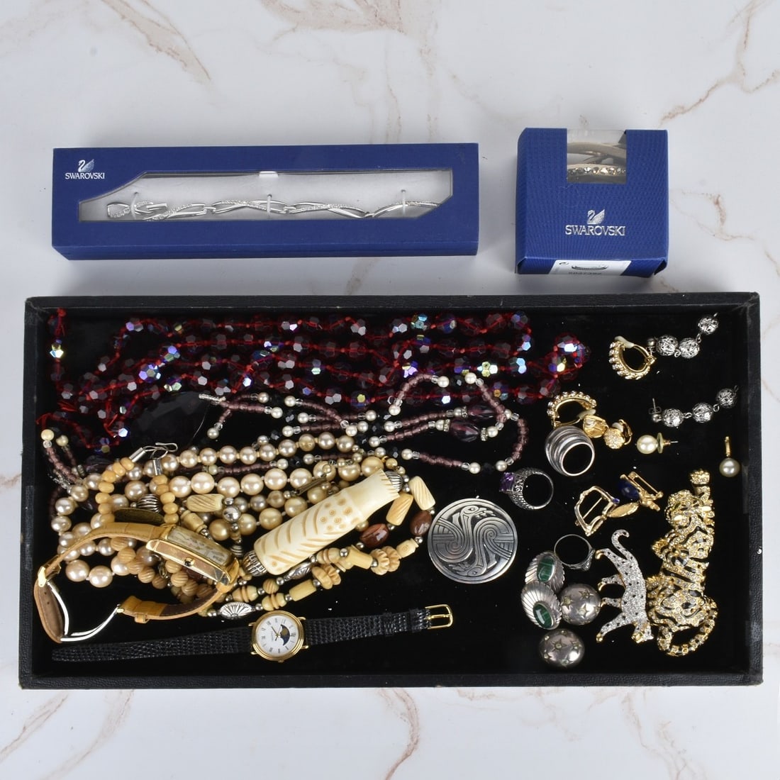 Tray Lot of Costume Jewelry: Tray Lot of Costume Jewelry. To include: lady's Invicta and Tourneau quartz watches, two Swarovski bracelets, necklaces, brooches, earrings and rings. Variously accented with rhinestones, crystals, fa