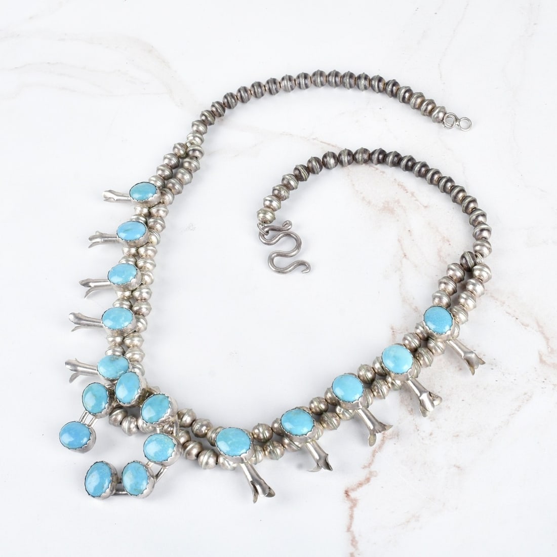 Turquoise and Silver Necklace: Vintage American Southwest Turquoise and Silver Squash Blossom Necklace. Measures 21" L, 1-3/4" drop. Approx. weight: 81.94 grams. Condition: Very good vintage condition. Estimate: $200.00 - $500.00 D