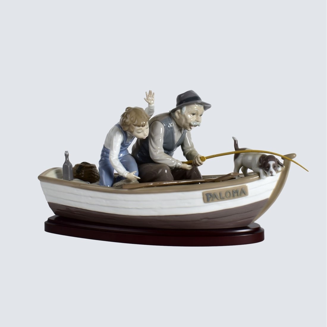Lladro "Fishing with Gramps" Group: Lladro "Fishing with Gramps" Porcelain Group Presented on a Wooden Stand. Signed and numbered 5215 on the base. Figurine measure 8-1/4" x 16" x 6-1/2". Condition: Good condition. Estimate: $200.00 - $