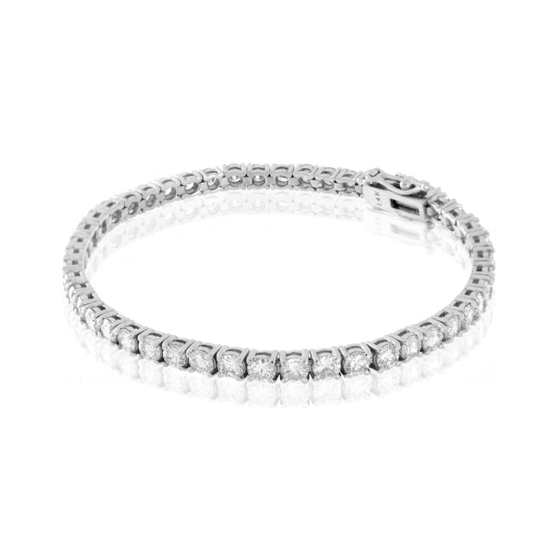 Diamond and 14K Tennis Bracelet: Approx. 7.50 Carat TW Forty Seven Round Brilliant Cut Diamond and 14 Karat White Gold Tennis Bracelet. Diamonds F-G color, VS1-VS2 clarity with a few SI1. Stamped 14K. Measures 7-1/16" L, 1/8" W. Appr