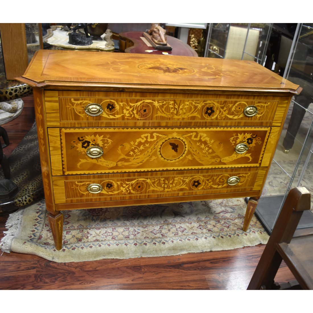 20th G. Maggiolini Style Chest of Drawers: 20th Century Italian Giuseppe Maggiolini style Marquetry Inlaid Chest of Drawers. Three drawers with brass pulls and stands on tapering legs. Measures 37" x 51" x 21-1/2". Condition: Some surface wear