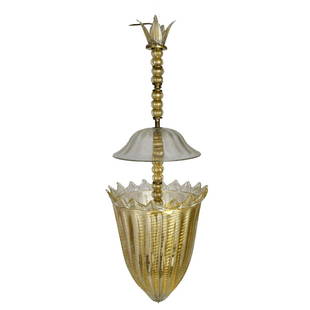 Murano Art Glass Gold to Clear Chandelier: Large Murano Art Glass Ribbed Gold Swirl to Clear Chandelier. Measures 32"L x 12"W Condition: Good Condition. Estimate: $500.00 - $800.00 Domestic Shipping: Third Party