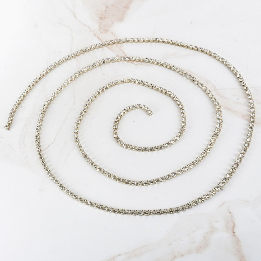 Rhinestone Necklace: Vintage Rhinestone and White Metal Necklace. Measures 46" L. Provenance: The Orianne Collins Collection. Condition: Very good condition. Estimate: $50.00 - $100.00 Domestic Shipping: $40.00
