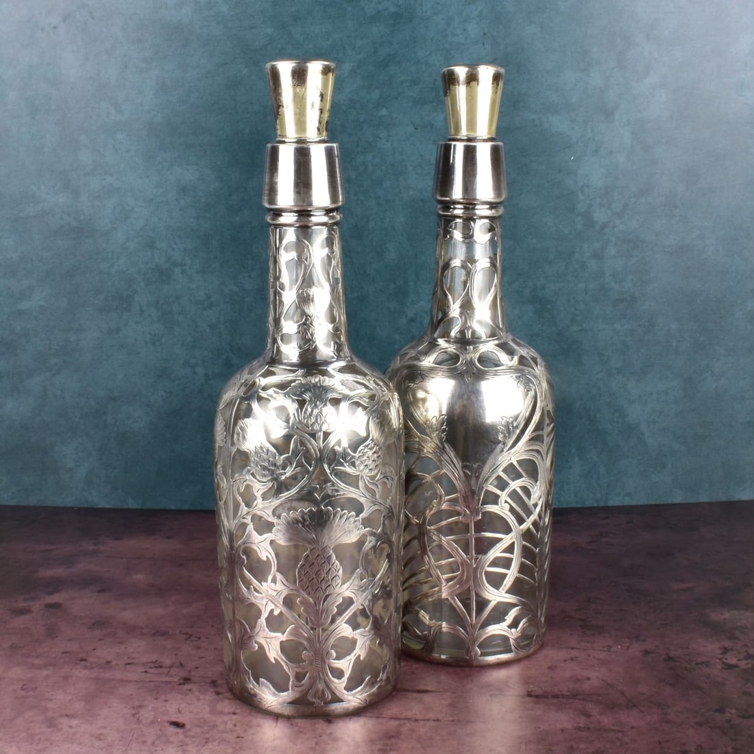 Pair of Black Star and Frost Fine Silver Bottles: Pair of Black Star and Frost Art Nouveau Fine .999 Silver Overlay Liquor Bottles. Stamped with makers mark and marked fine.999/1000 silver on the base. Bottle tops are stamped sterling. Measures 12" x