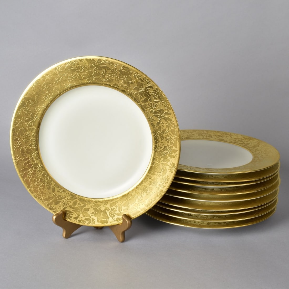 Ten Hutschenreuther Porcelain Dinner Plates: Grouping of Ten (10) Hutschenreuther Selb Gold Encrusted Porcelain Dinner Plates. Marked on the base. One plate is by Thomas Bavaria. Measures 10-7/8" diam. Condition: One plate has a hairline. A few