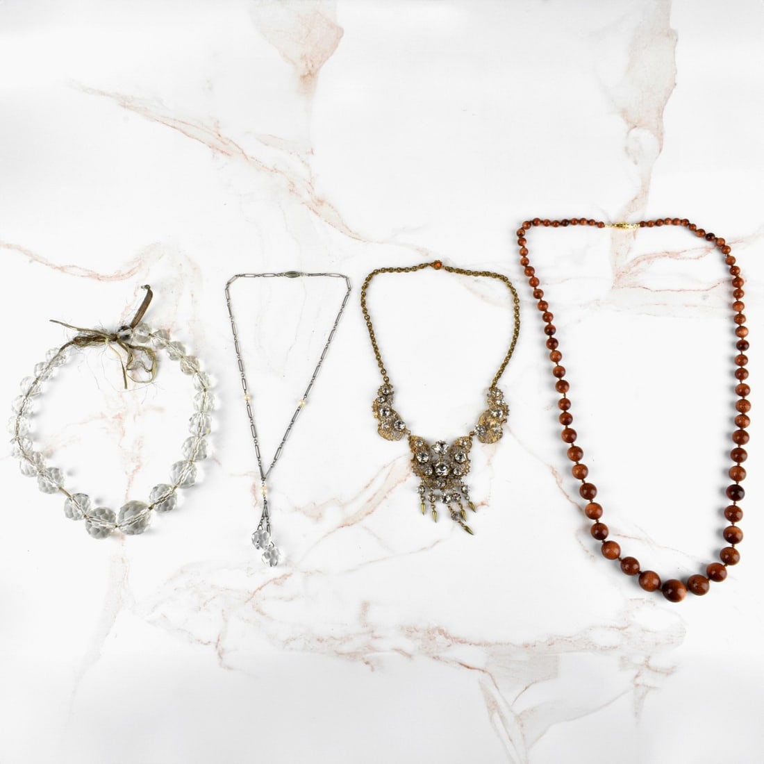 Antique Necklaces: Four Antique Necklaces. To include a graduated sunstone bead necklace, a faceted crystal bead necklace, a faceted crystal bead, pearl and white metal necklace and a faux diamond and gold tone metal ne