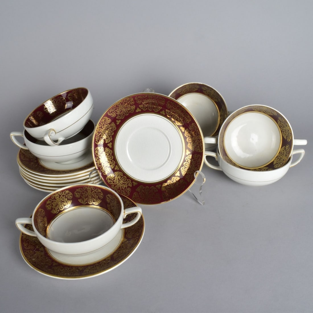 Antique Wood and Sons Cups and Saucers: Fifteen (15) Piece Antique Wood and Sons "Burgundy" Gilt Scrolled Porcelain Cups and Saucers. Marked wood & sons ralph 1750 moses 1751 enoch 1784. Cups measure 2" x 4-5/8". Saucers measure 6-1/2" diam