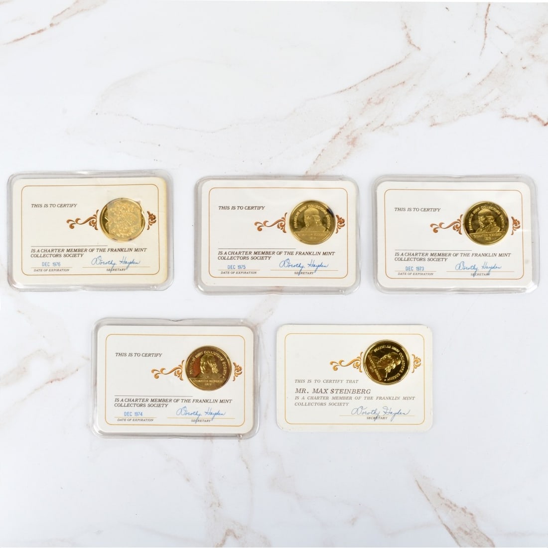Franklin Mint Tokens: Five Franklin Mint Collectors Society Charter Member Gold Plated Silver Tokens. Includes 1972-1976. Tokens measure 26.5mm. Each with certificate and plastic cases. Not weighable. Condition: Good vinta