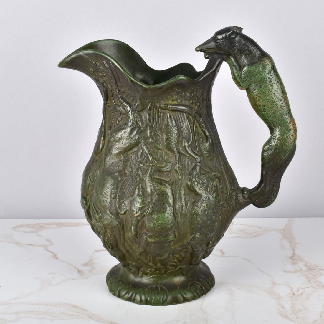 Bernardaud & Co Pitcher Hunting Scene: Bernardaud & Co Hunting Pottery Pitcher. The hunters catch surrounding the pitcher with a Fox handle, marked to bottom B & Co. 64. Measures 11-3/4" H x 10-1/2" W Condition: Has a chipped ear with a me