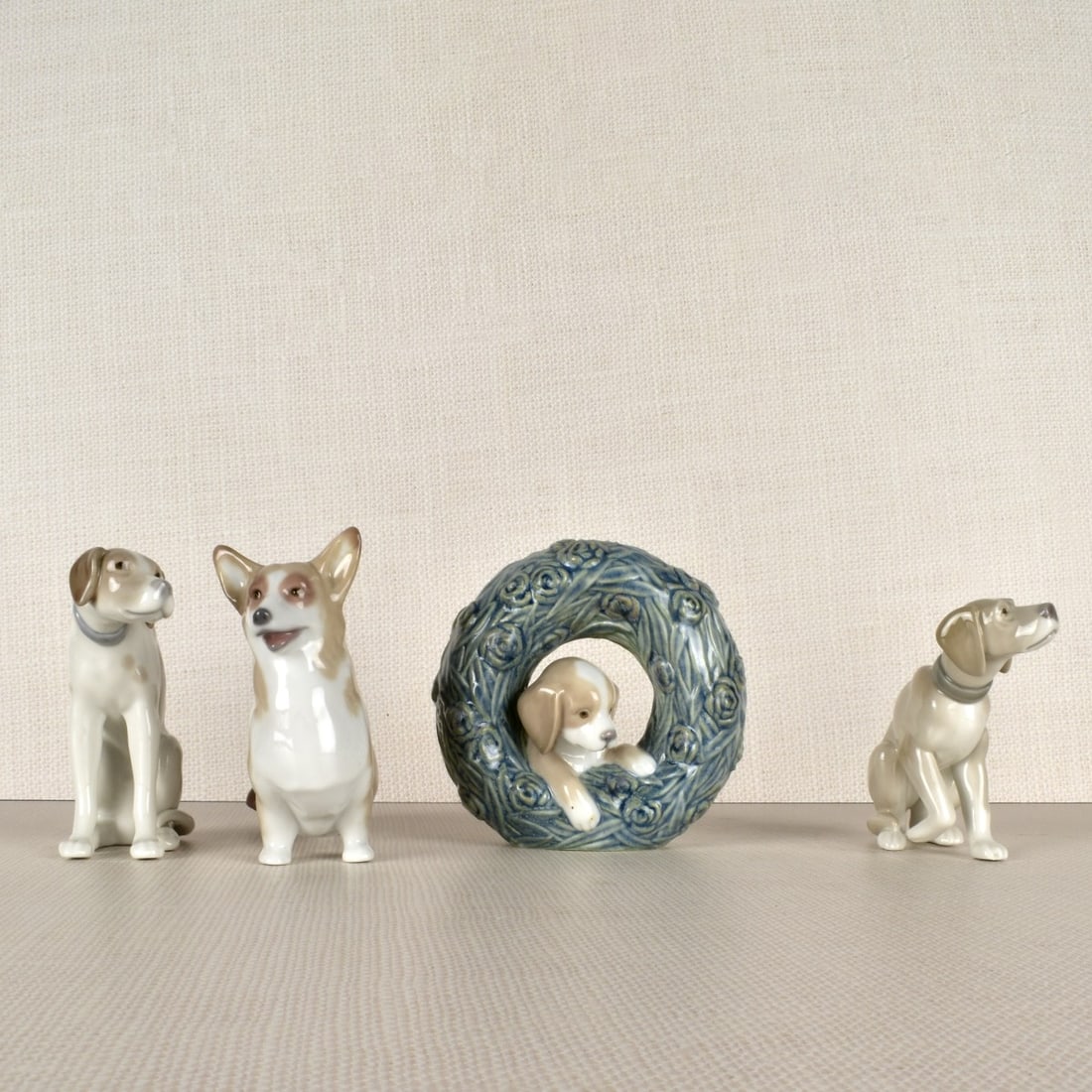 Lladro Porcelain Dog Figures: Three (4) Lladro Porcelain Dog Figurines. Properly marked on the bottom. Tallest measures: 4-1/2" H, 4-1/2" L, 2-1/2 " D. Condition: Good condition. Estimate: $100.00 - $200.00 Domestic Shipping: $58.