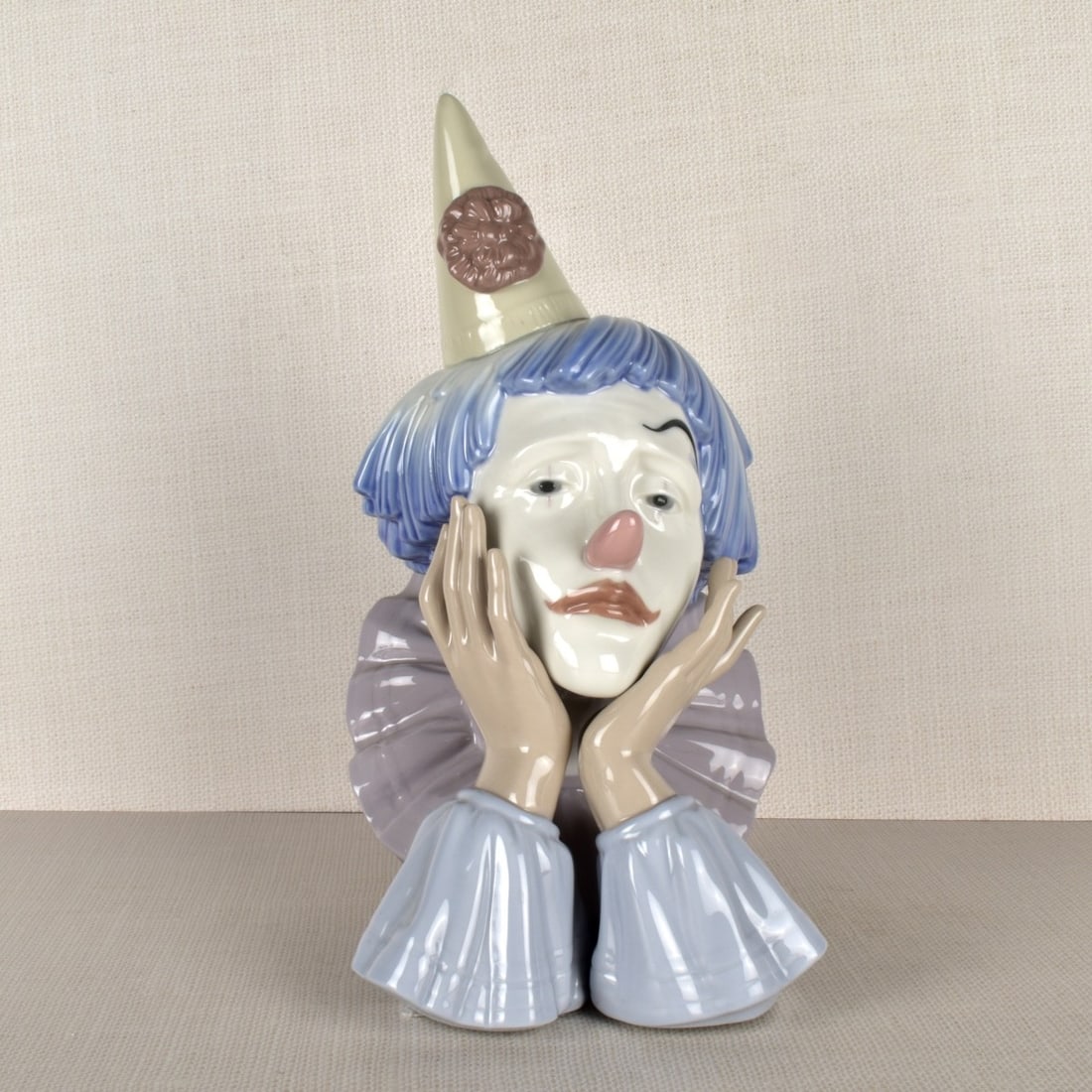 Lladro Figurine of a Sad Clown: Lladro Figurine of a Sad Clown Wearing a Party Hat With His Hands to his Face. Properly marked on the bottom. Measures: 12-1/4" H, 6" W, 8" D. Condition: Good condition. Estimate: $100.00 - $200.00 Do