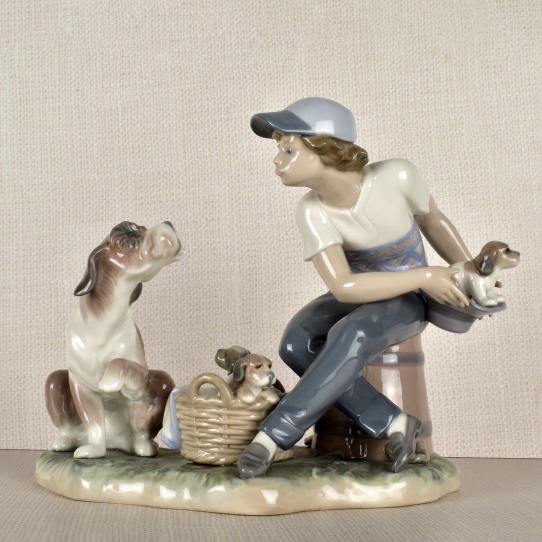 Lladro Figurine of a Girl: Lladro Porcelain Figurine of a Young Girl With a Mother Dog and Three (3) Young Pups. Properly marked on the bottom. Measures: 7" H, 8" W, 5" D. Condition: Good condition. Estimate: $100.00 - $200.00 