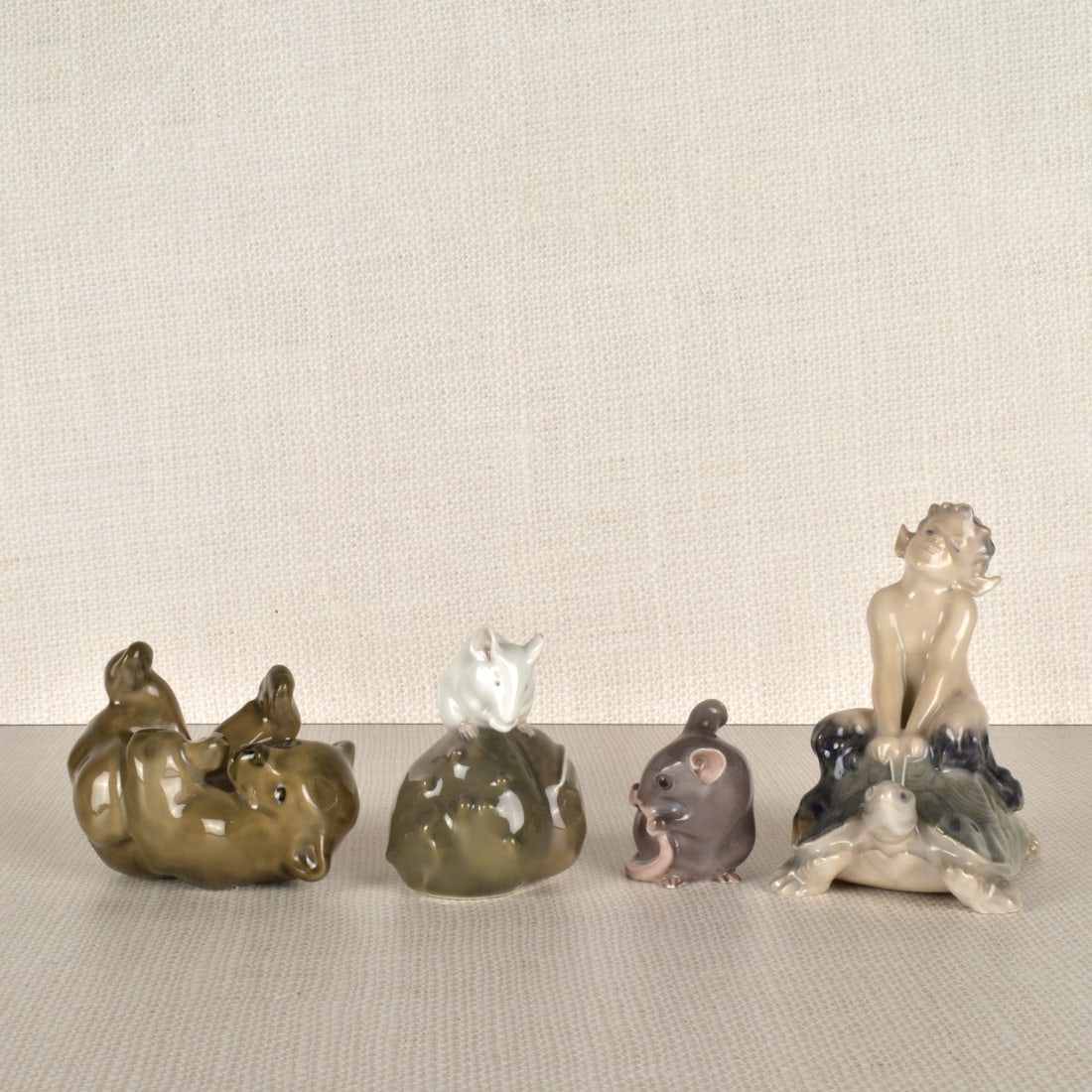 Four Royal Copenhagen Porcelain Figurines: Four (4) Royal Copenhagen Porcelain Figurines, two mice, one baby bear and a Satyr riding a turtle. Signed appropriately to bottom. Largest measures 4" H x 3-3/4 ' L x 2-1/2" W. Condition: Good condit