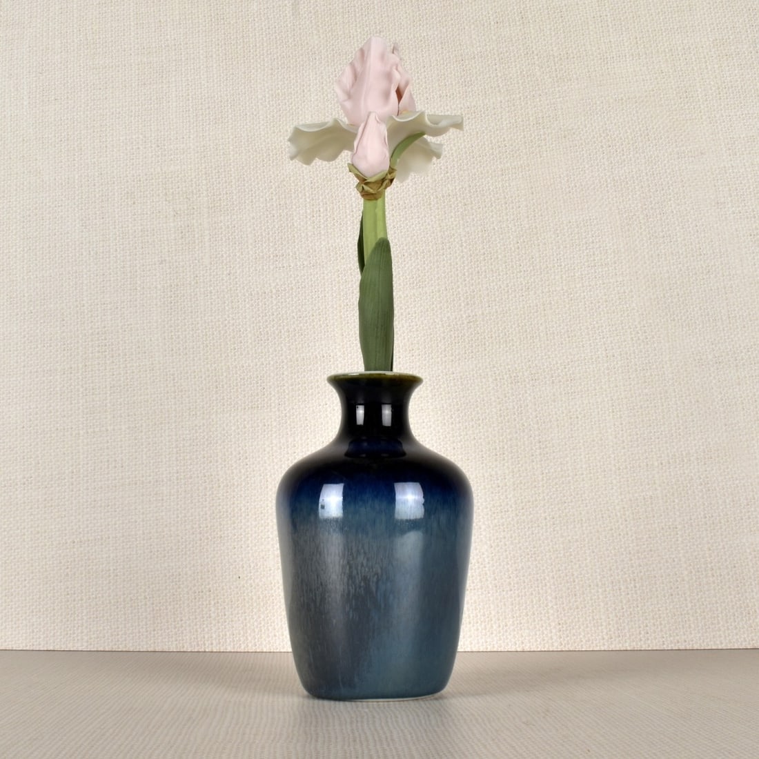 Lladro Porcelain Vase Figurines: Two pieces, a Lladro Porcelain blue vase with pink Iris Flower. Marked appropriately to vase bottom, no marking on flower. Vase 11" H x 3" Diameter, flower 9-14" H, Overall flower in sand measures 11"