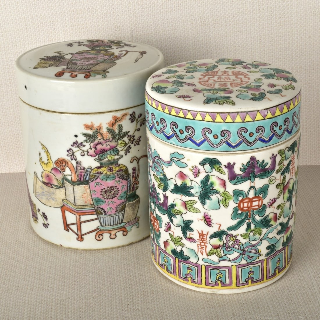 Chinese Porcelain Covered Jars: Two (2) Chinese Famille Rose Porcelain Covered Jars. One bears the Jiaging seal mark to the bottom with calligraphy to the side, the other with an illegible mark to the bottom. 20th century. Measures: