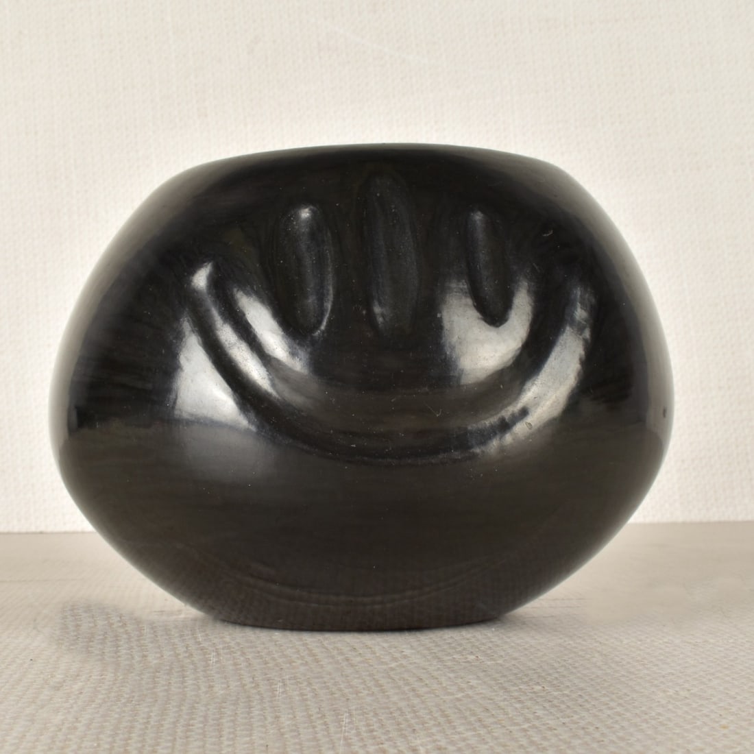 Santa Clara Native American Pottery Bowl: Santa Clara Native American Black Pottery Bowl Signed to bottom in pencil Ann Taliman Santa Clara 1973 Pue. Measures 3-3/4" H x 5-1/2" W. Condition: Good used condition, some scuffing. Estimate: $100.