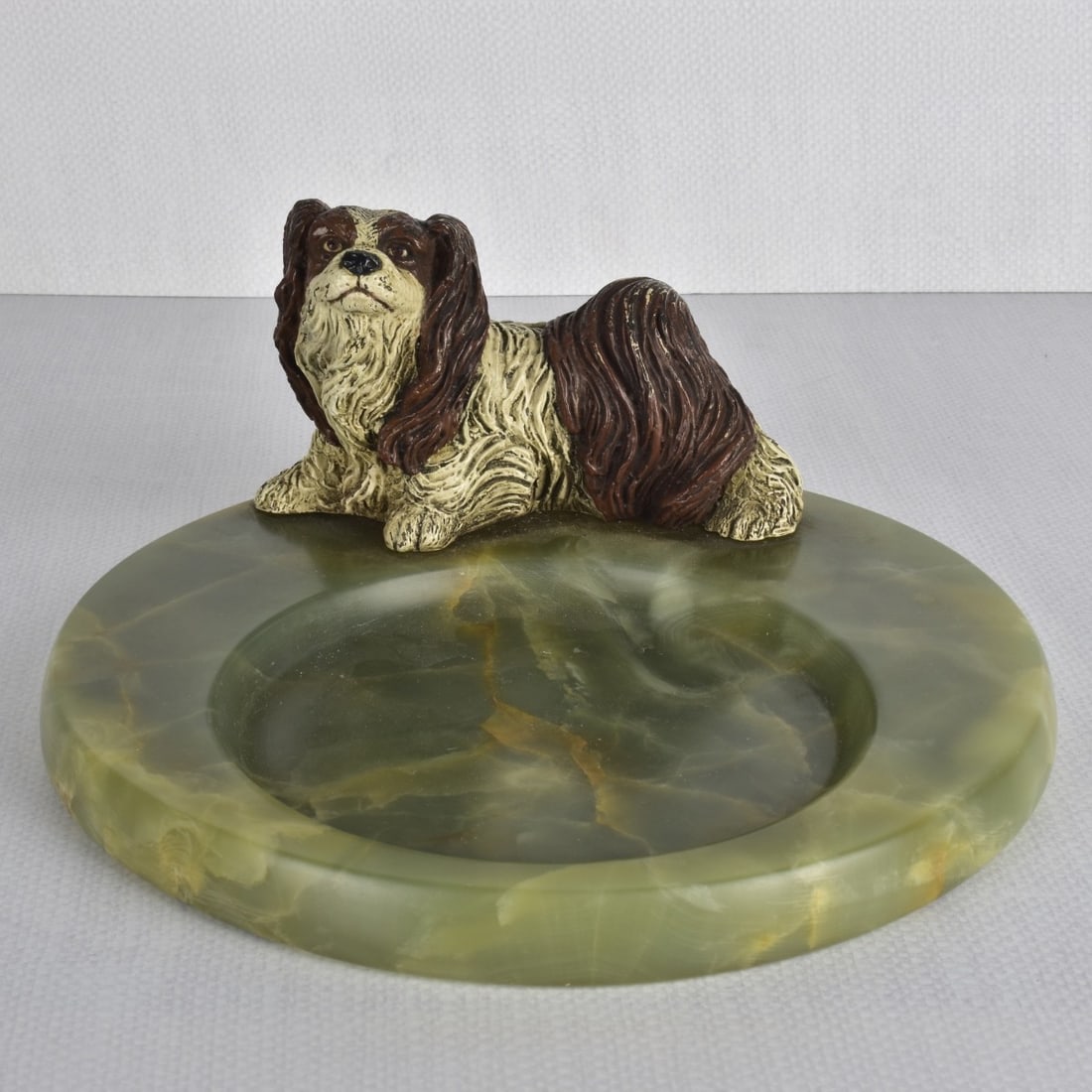 Pekinese Dog Dish Tray: Pekinese Dog Mounted on a Green Onyx Round Dish. Late 20th century. Dog measures: 3-3/4" H, dish measures: 3/4" H, 9-1/4" Dia. Condition: Good condition. Estimate: $50.00 - $100.00 Domestic Shipping: 