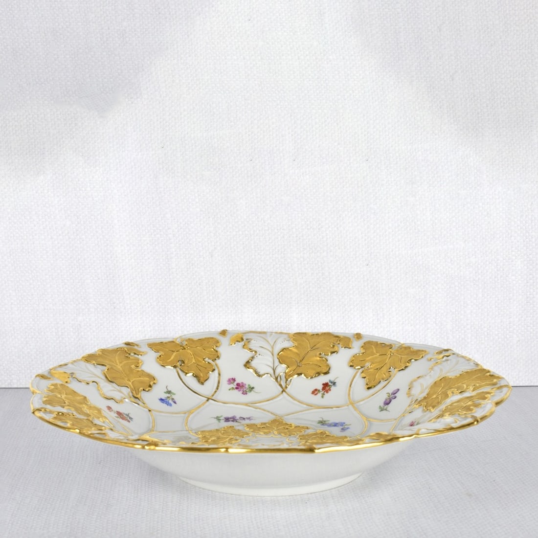 Meissen Gold Gilt Bowl: Meissen Heavy Gold Gilded Bowl Small Flowers Within Bright Gold Enamel Scrolls. Marked to the bottom with the Meissen crossed swords under glaze and painters number "23". 20 th century. Measures: 2" H