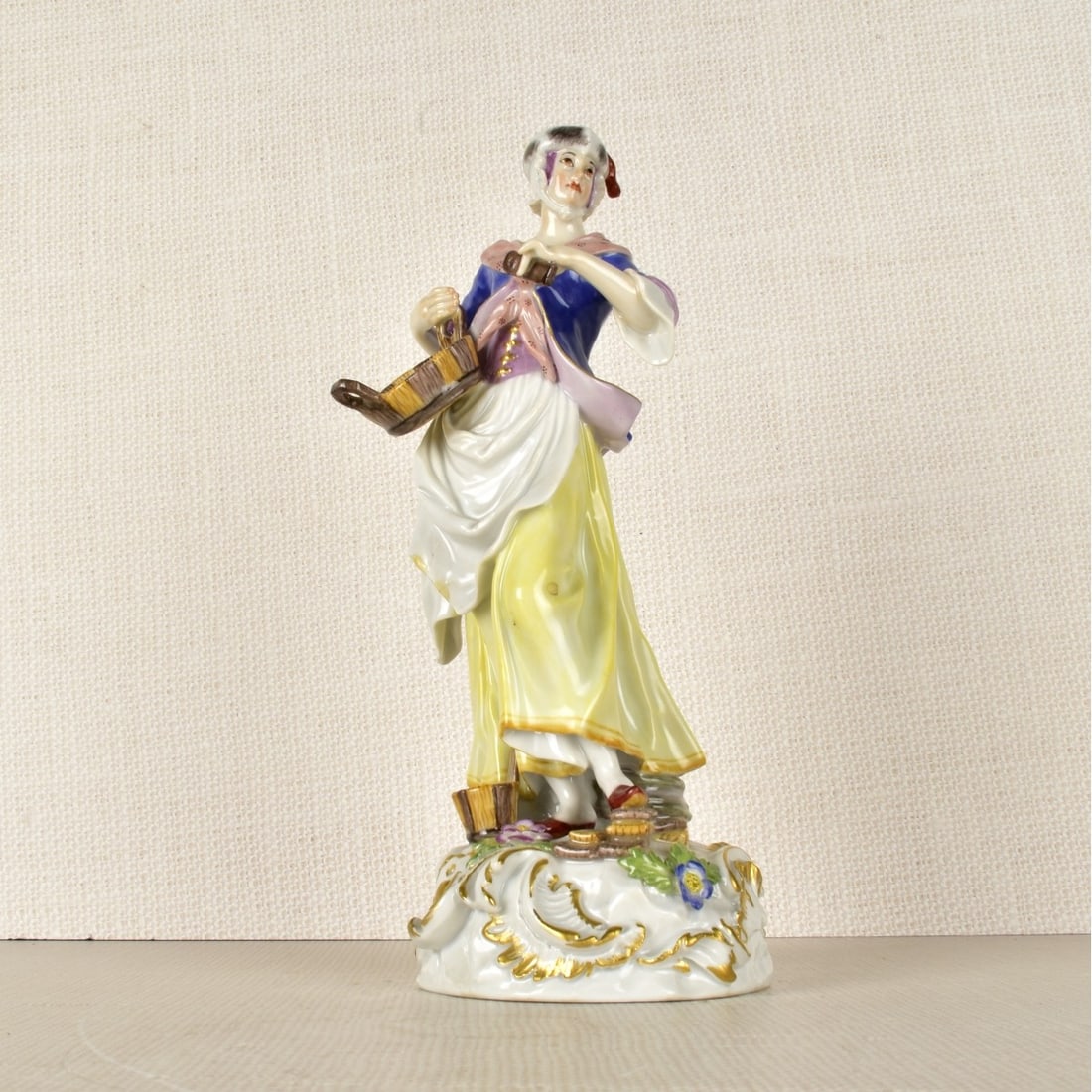 Meissen Figurine of Woman with a Basket: Meissen Porcelain Figurine of a Woman Holding a Basket and Wearing a Cap, Marked with the Meissen Crossed Swords Under Glaze as well as Incised Number "142" and Number "73163". 19th Century. Measures"