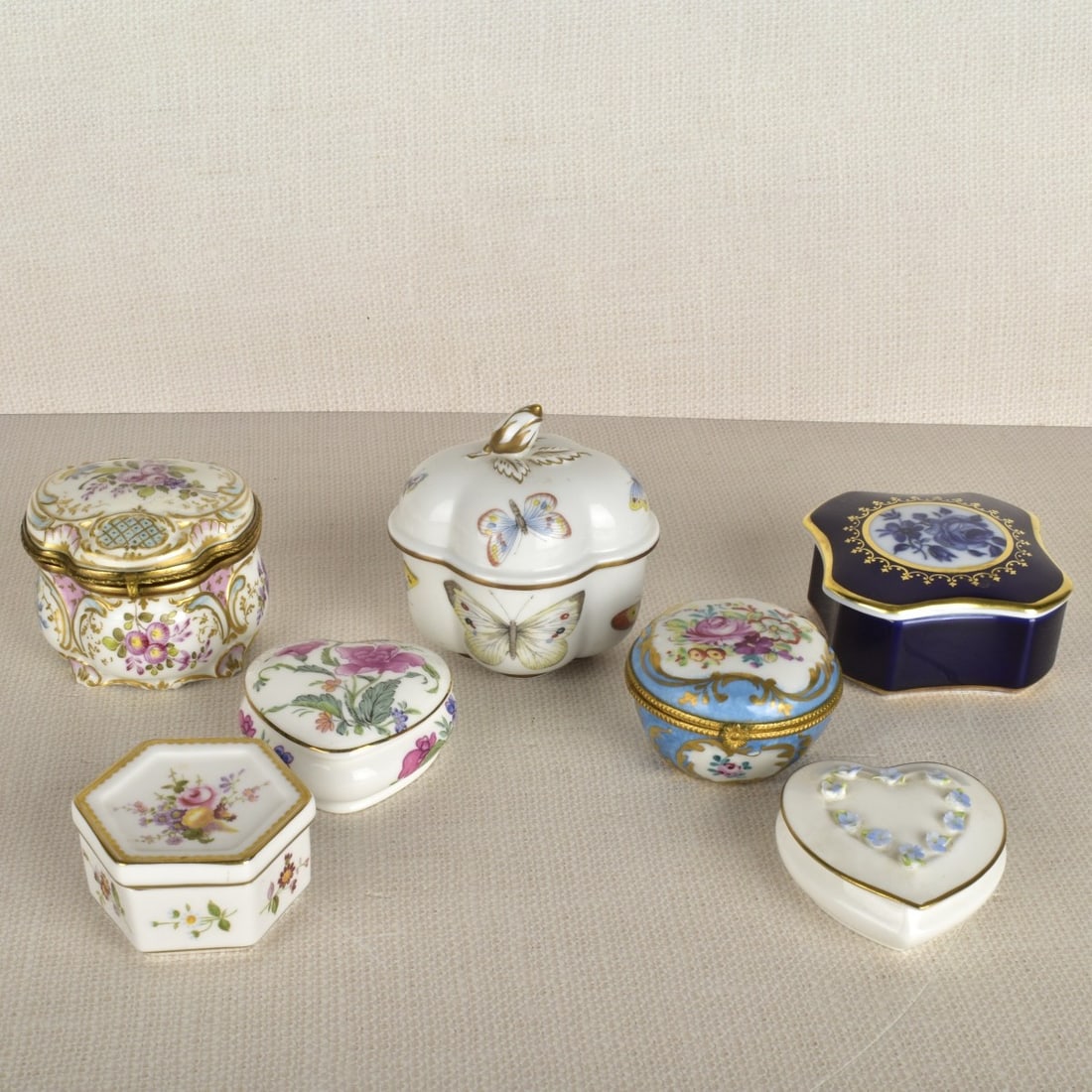 Lot of Miniature Porcelain Boxes: Lot of Miniature Porcelain Boxes, Including Coalport , and Royal Crown Derby. Largest measures: 3-1/2 H, 3-1/2" L, 3" D. Condition: Good condition, heart shape Coalport box has minor chips to flowers.
