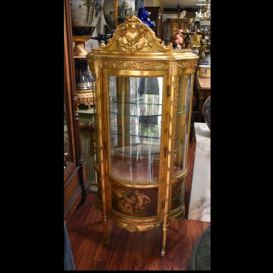 French Louis XVI Style Vernis Martin Vitrine: French Louis XVI Style Vernis Martin Vitrine with Gold Gilt Wood and Round Glass. Painted with Cherubs and floral sprays. With light and two (2) fitted glass shelves and one (1) cloth lined bottom she