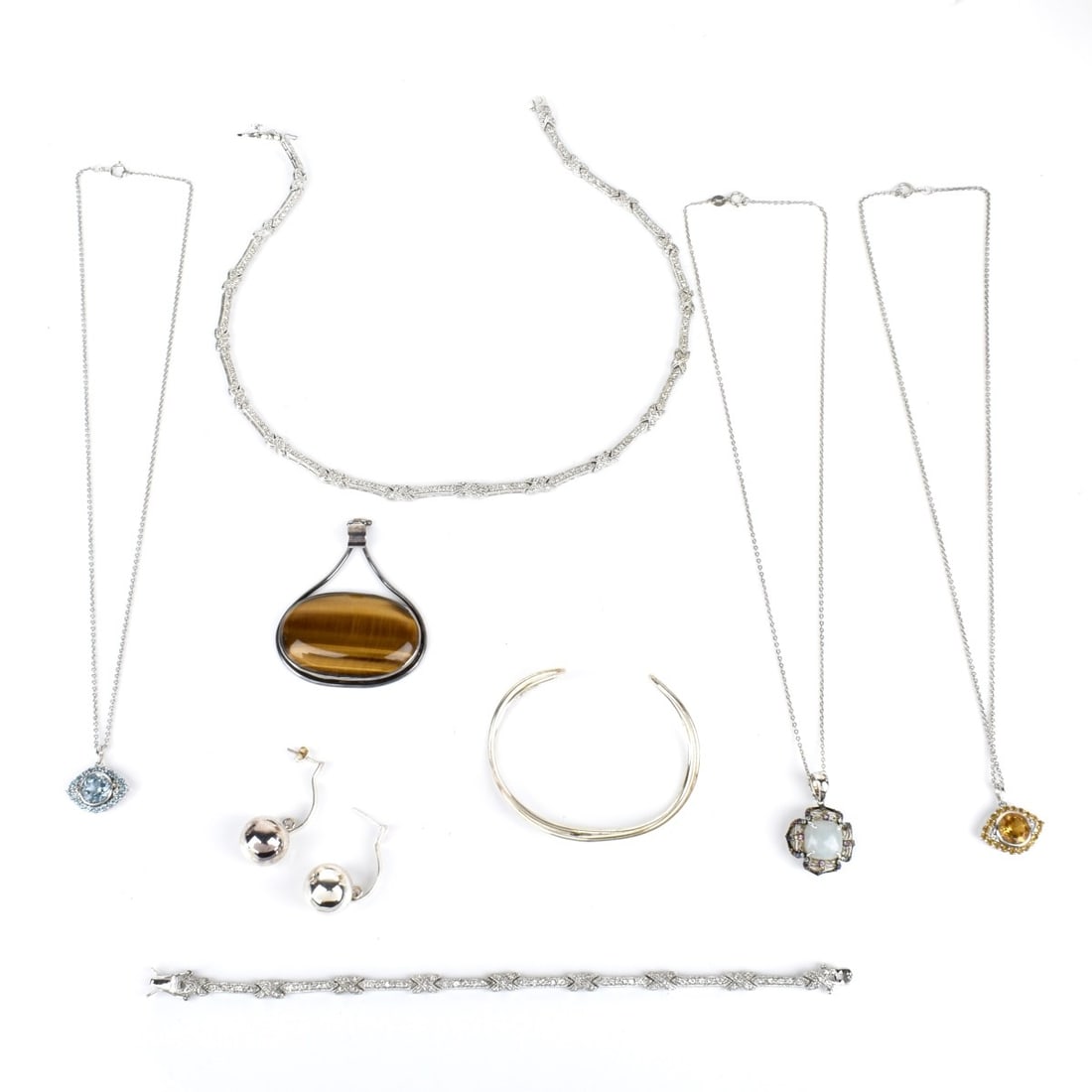 Sterling Silver Jewelry: Lot of Vintage Sterling Silver Jewelry. To include three pendant necklaces, a necklace and matching bracelet, a pendant, a cuff bangle bracelet and a pair of earrings. Variously accented with tiger ey