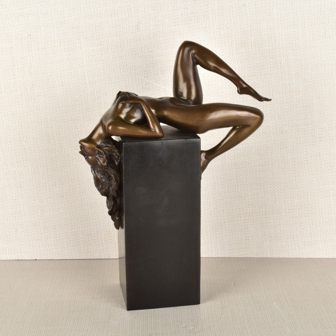 Art Nouveau Style Figure of a Reclining Nude: Bronze Figure of a Reclining Nude with Bent Knees and Long Flowing Hair on a Tall Rectangular Base. Attached round seal with a sailing vessel in the center surrounded by the words "Garantie de Bronze