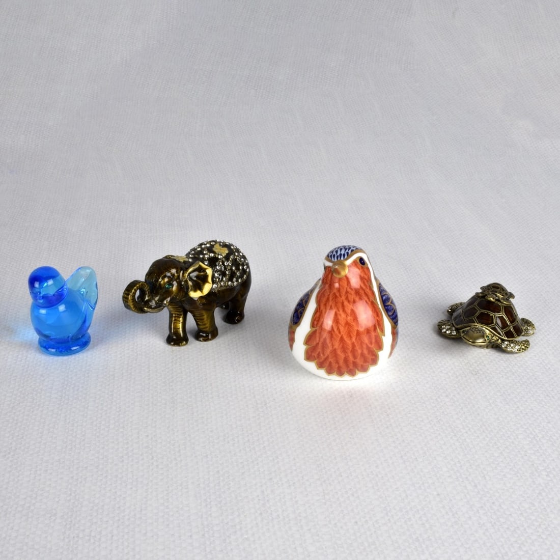 Group of Various Animals: Grouping of Four (4) Various Animals. Consisting of one (1) English Crown Derby bone china robin paperweight, measures: 2-3/4" H, 2-1/4" W, 4" D, one (1) blue glass "Bird of Happiness", measures: 2" H