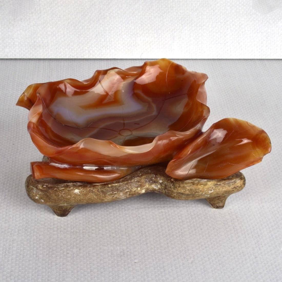 Carnelian Agate Bowl: Antique Carnelian Agate Polished Bowl in the Form of a Leaf on a Fitted Carved Wood Base. Bowl measures: 1-3/4" H, 6-1/2" L, 7-1/2" D. Provenance: Estate of Jacqueline Kott, Miami, Florida. Condition: