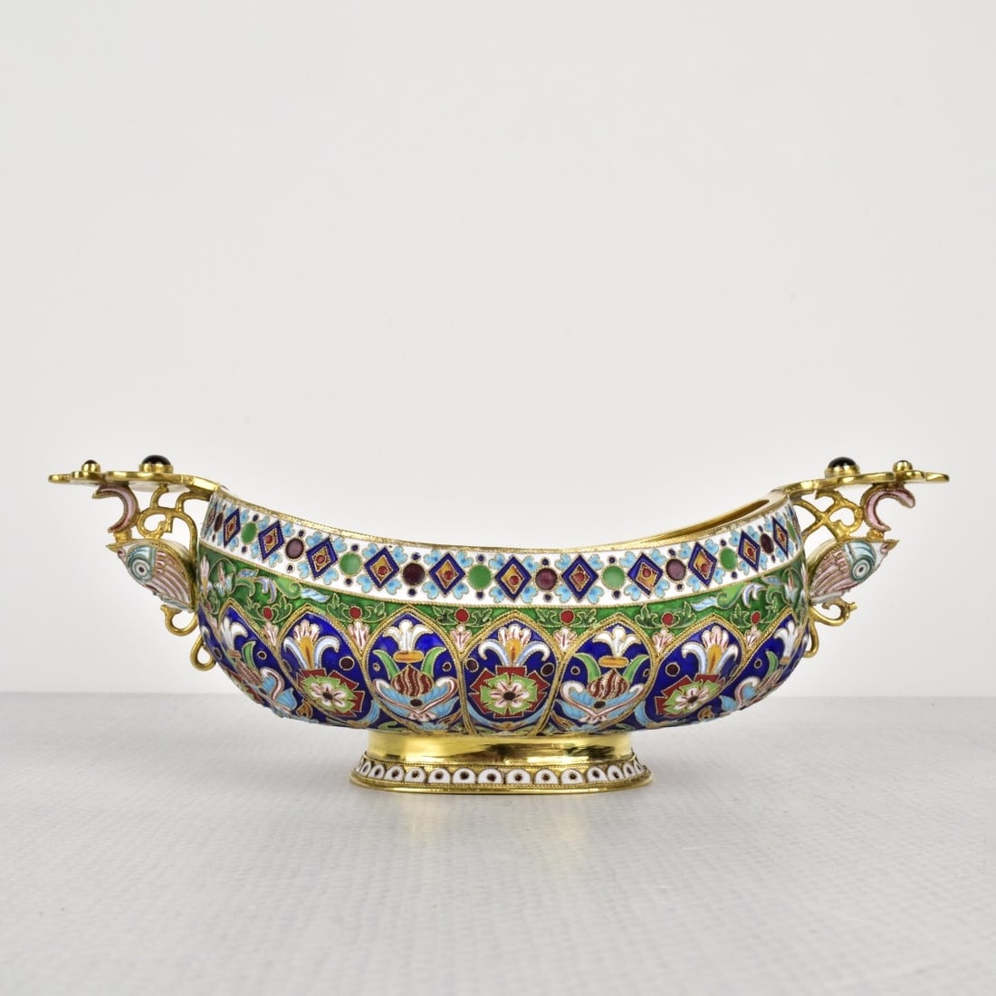 Russian Silver-Gilt and Cloisonne Enamel Oval Bowl: 20 th Century Russian Silver-Gilt and Cloisonne Enamel Oval Bowl with a Gold Wash Interior with Attached Handles and inset Garnet Cabochons. Bears the name Carl Faberge. Measures: 2-1/2" H, 7" W, 3-5/
