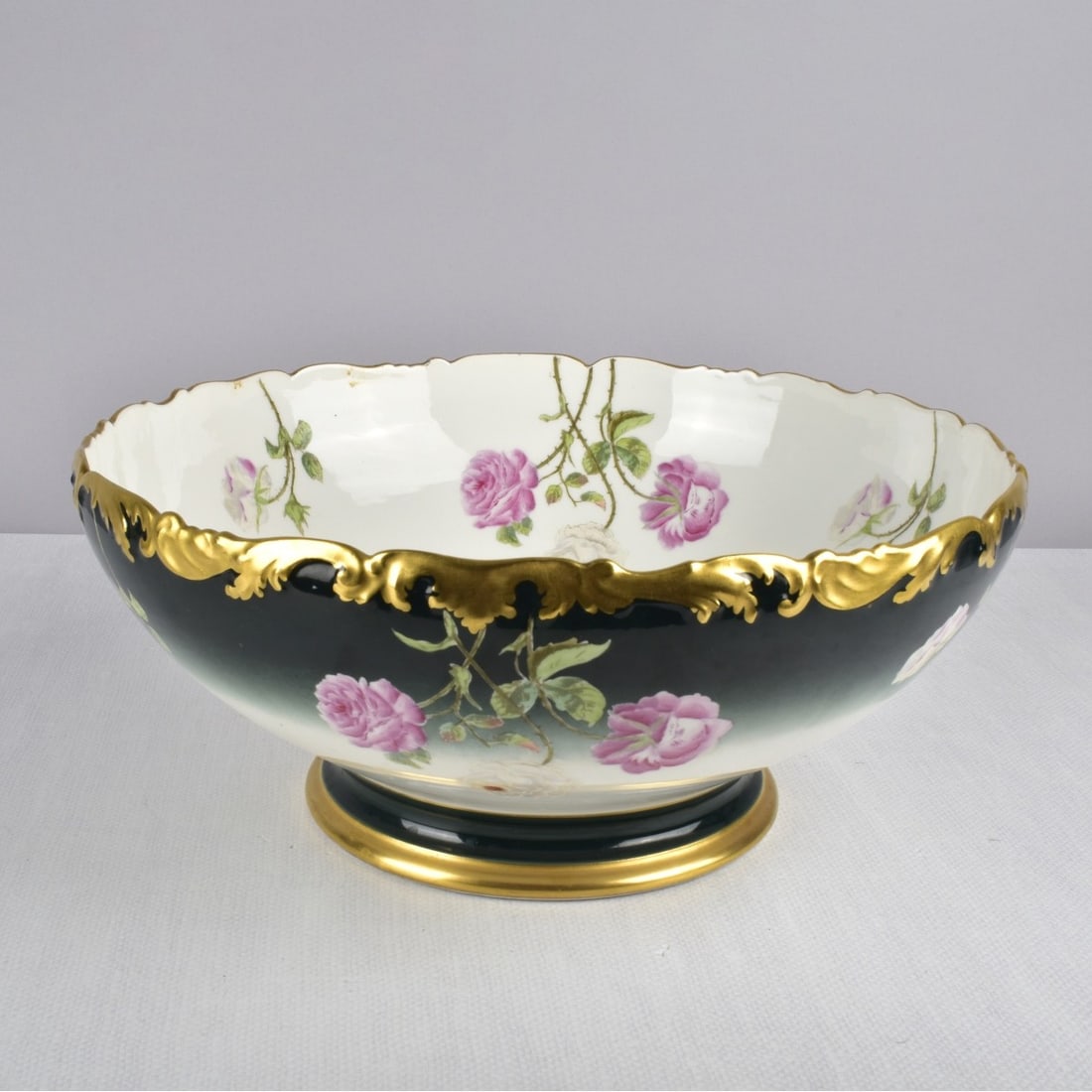 Vintage Porcelain Punch Bowl: Vintage Porcelain Punch Bowl Marked "T&V Limoges". Decorated with flowers and stems with leaves and a heavy gold rim. Measures; 6" H, 14" Dia. Condition: Good condition. Estimate: $100.00 - $150.00 Do