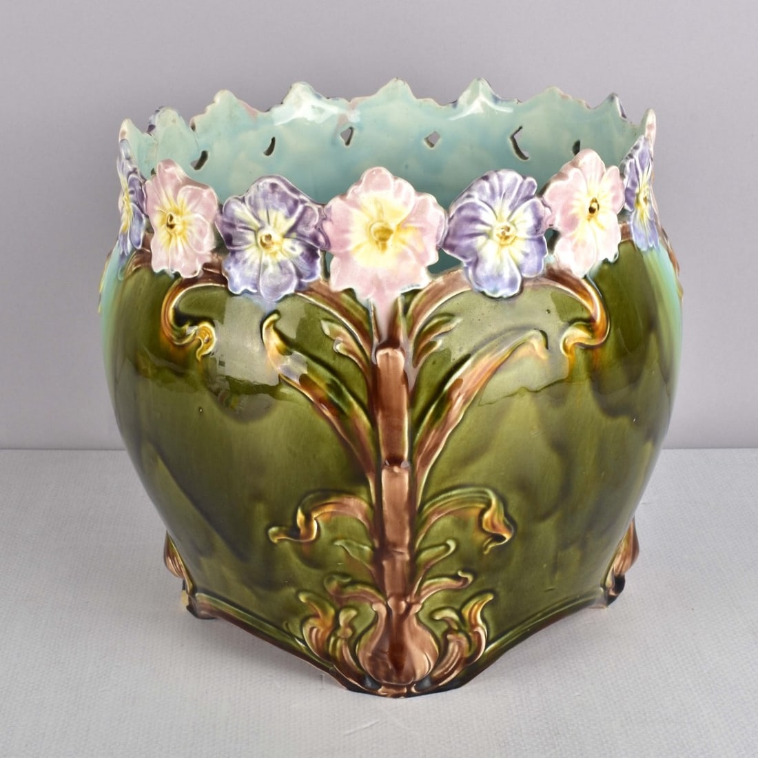 Art Nouveau Majolica Jardiniere: Antique Art Nouveau Italian Majolica Jardiniere Decorated with Pastel Painted Pansies. Impressed numbers "4568 above 63" to the bottom. Measures: 9-1/4" H, 9-1/2" Dia. Condition: Very good condition. 