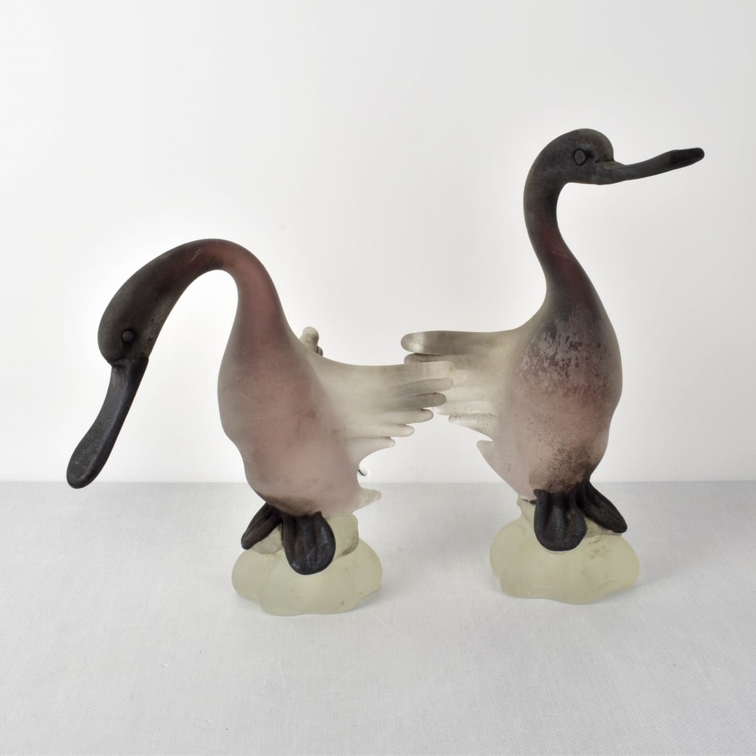 Gino Cenedese, (Italian, 1907-1973): Gino Cenedese, (Italian, 1907-1973) Pair of Venetian Frosted Murano Glass Swan Figurines. Tallest measures: 13-1/4" H, 6-1/2" W, 8-1/2" D. Shortest measures: 10-1/2" H, 6-1/2" W, 10" D. Condition: Goo