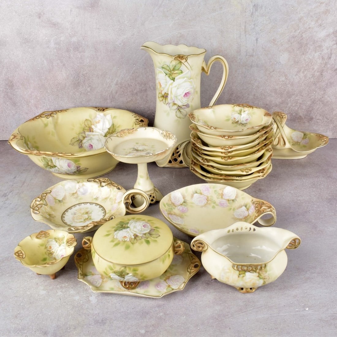 Antique Royal Bayreuth Bavaria Porcelain: Nineteen (19) Antique Royal Bayreuth Bavaria Porcelain Pieces in the White Rose Pattern. Consisting of one (1) large pitcher, one (1) large fruit bowl, nine (9) small berry bowls, one (1) small pedest