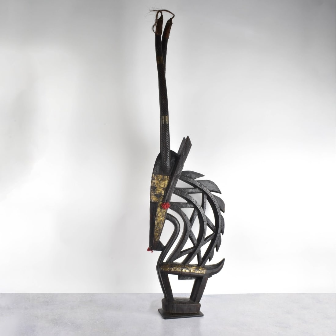 Carved African Wood Headdress: Carved African Wood and Polychrome Chi Wara Headdress Mali. 20th century. Measures: 44" H, 12" W, 3-1/2" D. Kodner Galleries offers phone and absentee bidding at a low, flat 21% buyer’s premium with