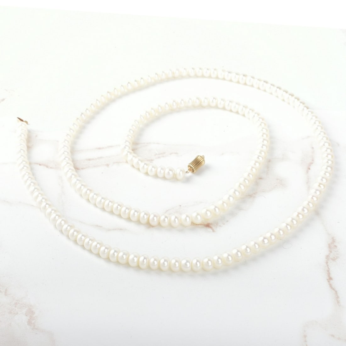 Pearl and 14K Necklace: Vintage Single Strand 6.5mm Baroque Pearl Necklace with 14 Karat Yellow Gold Clasp. Pearls with good luster and polish. Clasp stamped 585. Necklace measures 32" L. Approx. weight: 49.58 grams. Kodner 