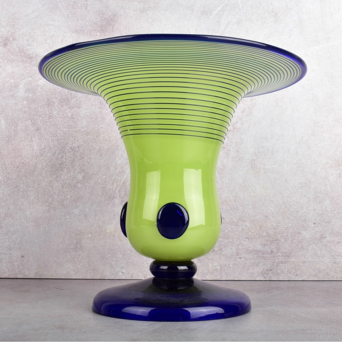 Loetz Bohemian Art Glass Vase: Loetz Bohemian Art Glass Footed Vase. Cobalt blue and apple green glass with cobalt blue glass applications and threads. Measures: 7-1/2" H, 8-1/4" Dia. Kodner Galleries offers phone and absentee bidd