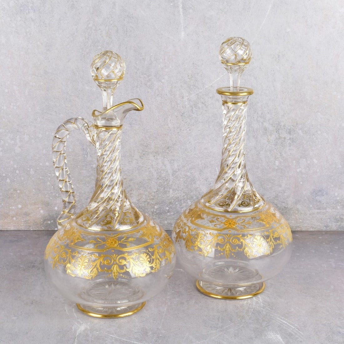 French Crystal Gold Trimmed Service Ware: French Crystal Gold Trimmed Service Ware. An ewer and matching decanter with Art Nouveau gold trim. Both matching and have fitted stoppers. Each measure: 12" H., 7" W. Kodner Galleries offers phone an