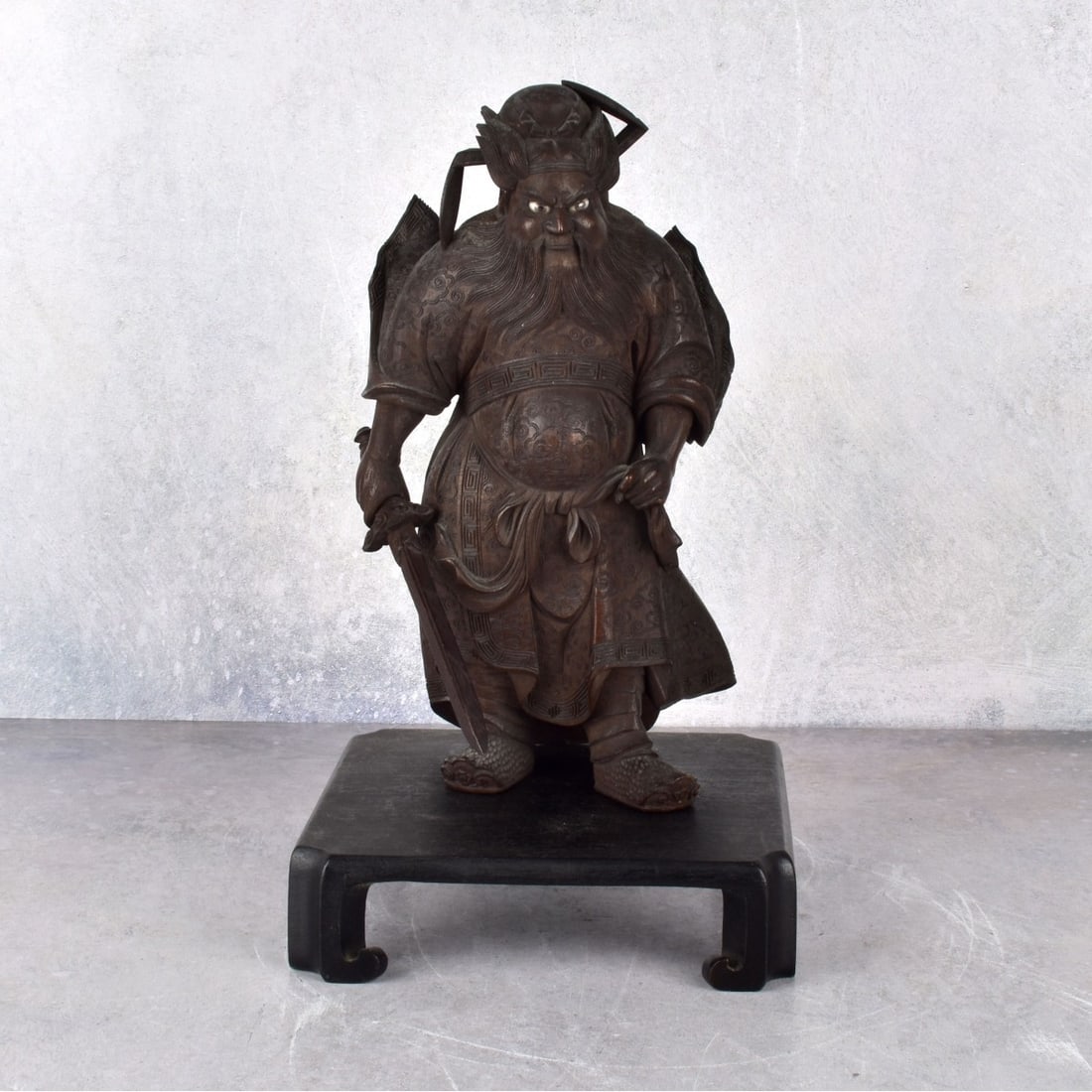 Antique Chinese Guan Yu Wood Figurine: Antique Chinese Guan Yu Wood Figurine Holding Sword having Painted Glass Eyes. Incised to the bottom. Accompanied with a painted wood stand. Figure measures: 9" H., 5" W., 3-1/2" D. Kodner Galleries o