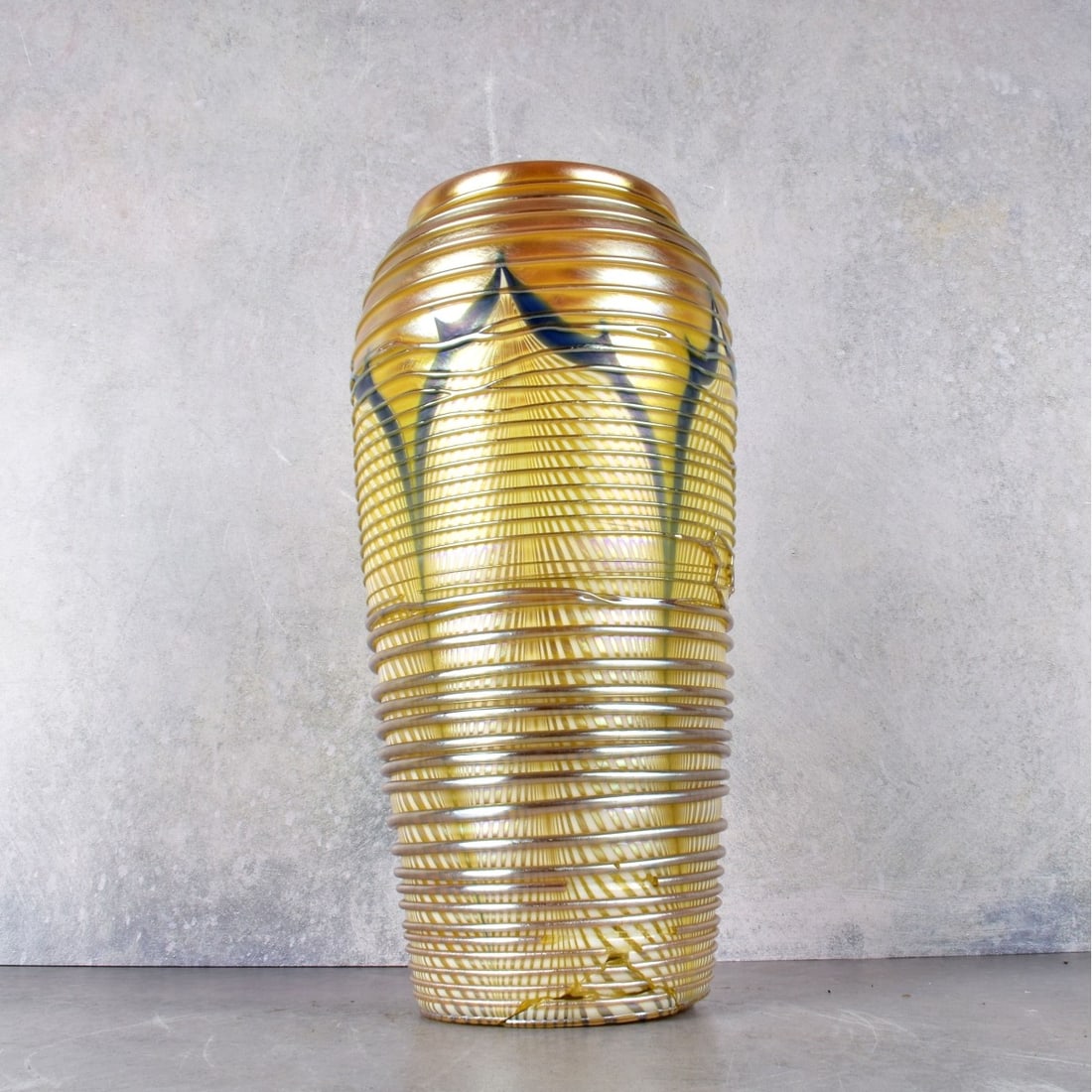 Hand Blown Vintage Art Glass Vase: Vintage Hand Blown Art Glass Vase with a Pulled Feather Design and Glass Threads on Gold Iridescent Glass. Measures: 10-3/8" H. Kodner Galleries offers phone and absentee bidding at a low, flat 21% bu