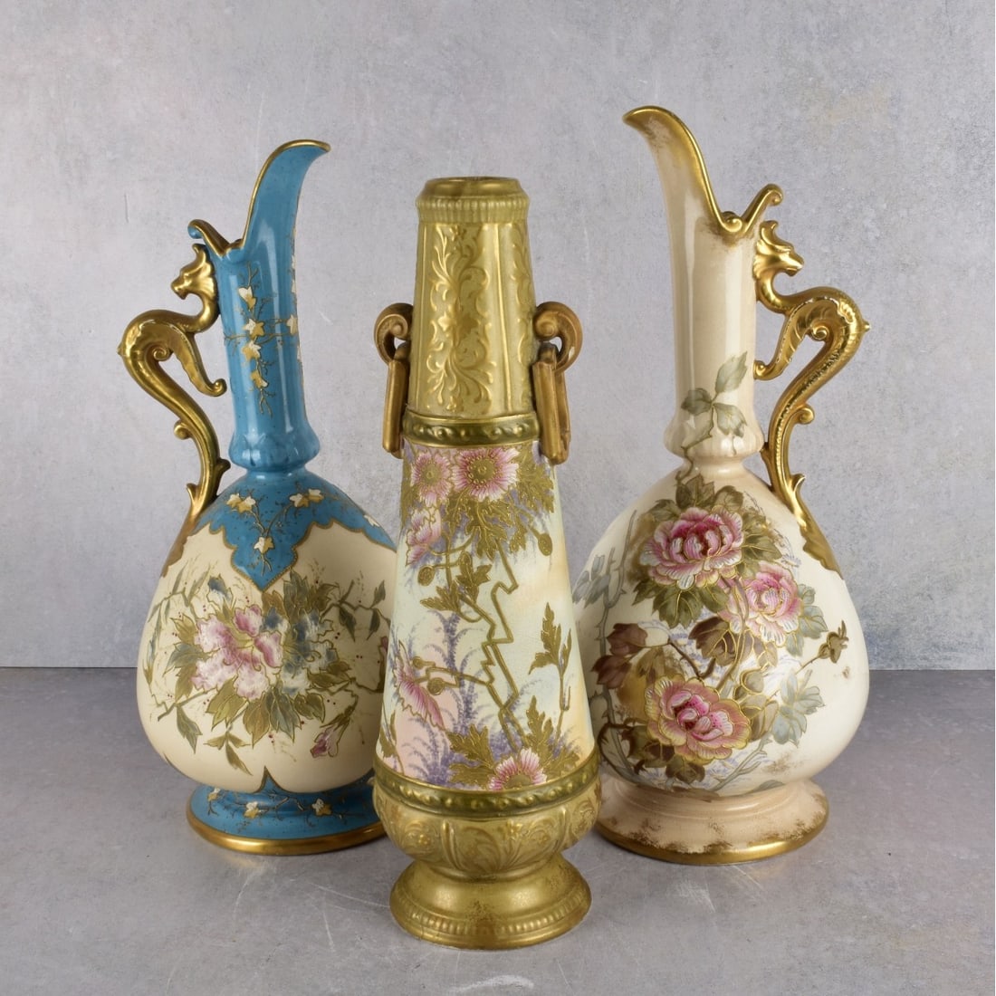 Antique Royal Bonn Porcelain Pieces: Three (3) Antique Royal Bonn Hand Painted Porcelain Pieces. Consisting of two (2) ewers and one (1) vase. Ewers measure: 14" H., 6" Dia., vase measures: 13-1/4" H., 3-7/8" Dia. Kodner Galleries offers